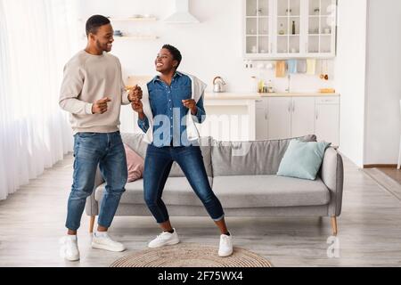 Portrait of joyful afro couple dancing at home Stock Photo