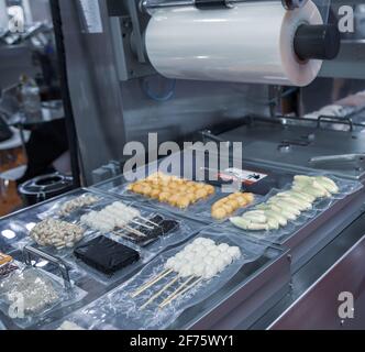 Linear tray food heat sealing and packaging machine Stock Photo