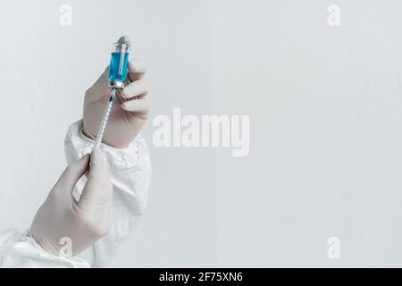Cropped view of scientist in latex gloves holding vaccine and syringe Stock Photo