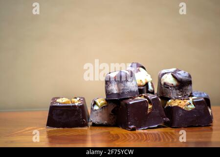 dark chocolates with almonds and nuts on a wooden chopping board Stock Photo