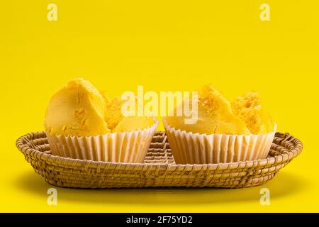 Yellow collection. Side view of egg yolk threads yellow cotton candy cake in bamboo tray on yellow background. Stock Photo