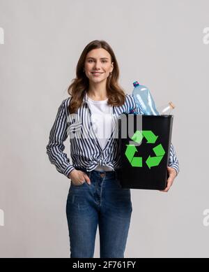 Zero Waste Concept. Young Smiling Female Holding Container With Empty Plastic Bottles Stock Photo
