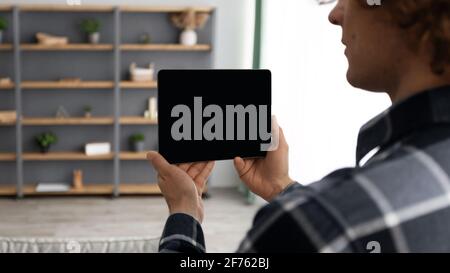 Man Holding Tablet With Empty Screen Standing At Home, Mockup Stock Photo