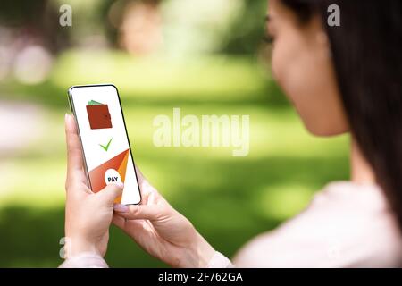 Woman paying online, using app on mobile phone Stock Photo