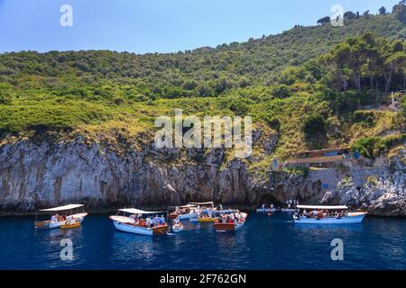 Tourists waiting to enter the Blue Grotto (Grotta Azzurra) by rowing boat on the Island of Capri, Italy Stock Photo