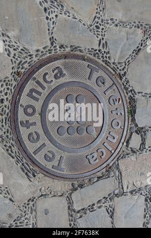 A manhole cover for the telephone utility company in Spain. Telefonica is the name of the main Spanish telephone company Stock Photo