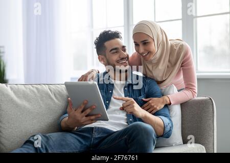 Young muslim couple using mobile app on digital tablet Stock Photo