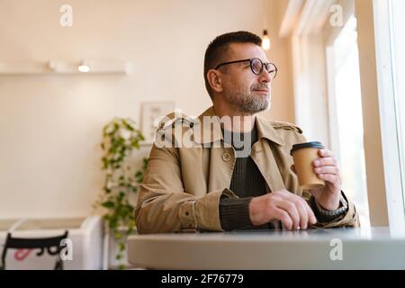 Handsome confident businessman having breakfast in modern coffee shop Stock Photo