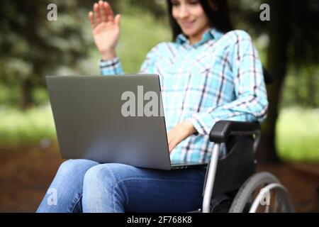 Woman in wheelchair is working on laptop Stock Photo