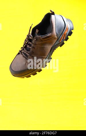Men's shoes. Stylish men's shoes, sneakers in isolation, on a yellow background, levitation. Stock Photo