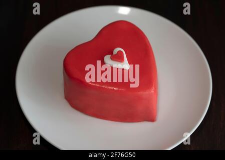 Heart shaped chocolate cake on plate on dark wooden background Stock Photo