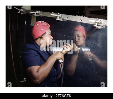 WW2 1940's USA War Work Production Aviation manufacturing plant with a real-life 'Rosie the Riveter' operating a hand drill at Vultee-Nashville, Tennessee, working on an A-31 Vengeance dive bomber. Date February 1943 World War II Stock Photo