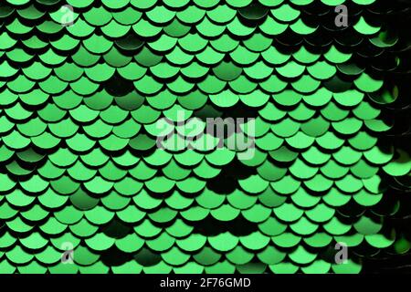 Sequins green shiny background.Texture scales with Sequins close-up.Scales background.Shiny texture material .iridescent fabric.sparkling sequined Stock Photo