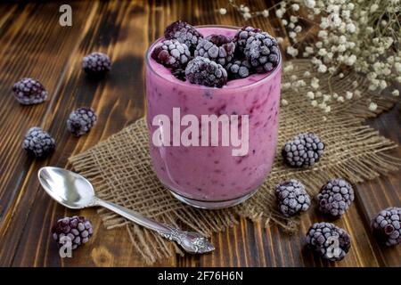 Yogurt with frozen blackberries  on the rustic wooden background Stock Photo