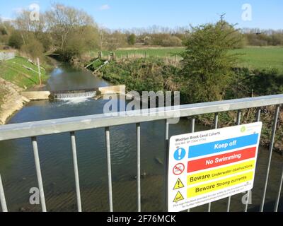 Warning notice on the bridge over the Wootton Brook canal culvert in Upton Country Park; part of the water management for the Upton new housing. Stock Photo