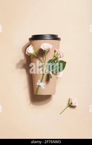 reusable eco coffee or tea cup with branch of roses on beige background. Sustainable lifestyle. Eco friendly and Zero waste concept.Flat lay  Stock Photo