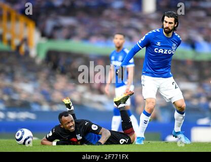 Crystal Palace's Jordan Ayew (left) goes down under the challenge from Everton's Andre Gomes (right) during the Premier League match at Goodison Park, Liverpool. Issue date: Monday April 5, 2021. Stock Photo