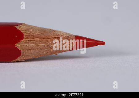 Red sharpened pencil point to the left on a white background copy space to right Stock Photo