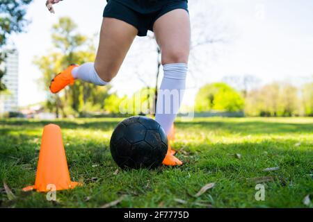 Young female soccer player practicing on field. Stock Photo