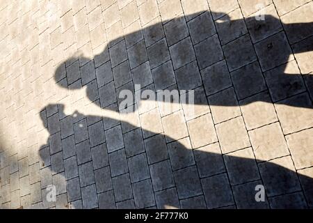 two shadows from the figures on the paving slabs Stock Photo