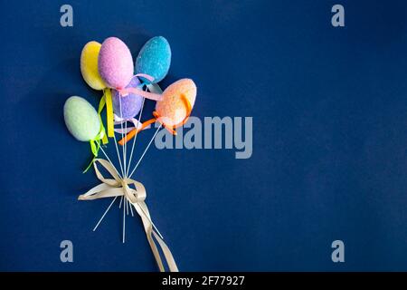 Fluffy colorful plastic eggs isolated on dark blue background. Easter concept. Copy space Stock Photo