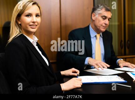 Two businesspeopTwo businesspeople discussing sitting at desk in their officele discussing sitting at desk in their office Stock Photo