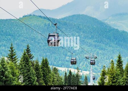 Cable car or funicular in Bachledova valley with mountains on the background. Bachledka gondola cable way in Slovakia, April 2021, Bachledova valley