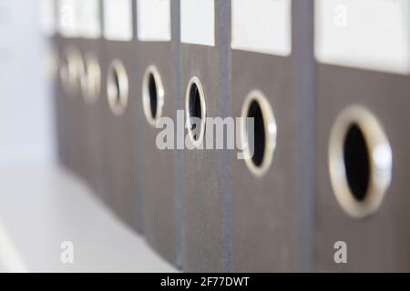 A number of office folders standing on the shelf of the cabinet Stock Photo