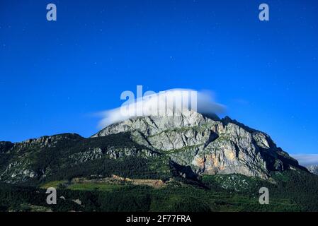 Full Moon night on the Pedraforca south face with the Pollegó Inferior peak covered by a cloud (Berguedà, Catalonia, Spain) Stock Photo