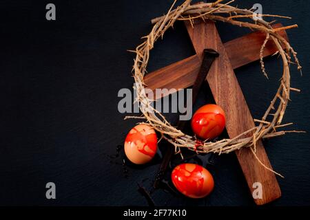 Easter holidays, christian celebration of Jesus resurrection and the Passion of Christ concept with eggs covered in blood of the Savior, a wooden cros Stock Photo