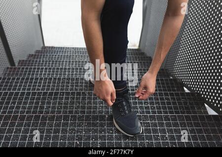 an anonymous male athlete laces up his shoes for running training Stock Photo