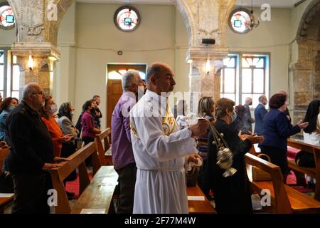 Iraqi Christians attend the Easter mass at the Grand Immaculate Church (al-Tahira-l-Kubra) in the Qaraqosh town (Al-Hamdaniya), 30 kilometers southeast of the city of Mosul.Easter is considered the greatest and largest Christian holiday, as it commemorates the resurrection of Christ from the dead after three days of his crucifixion and death, as written in the New Testament, in which the Great Lent that usually lasts forty days ends. During the liturgy the hymns are sung, parts of the Old Testament from the Bible are recited, the hymns of the Hallelujah are recited and the Gospel of the Resurr Stock Photo