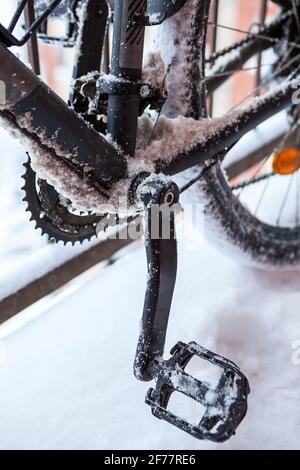 Close up view of bicycle sprocket, chain and pedals covered with ice and snow at wintertime, bicycling at winter Stock Photo