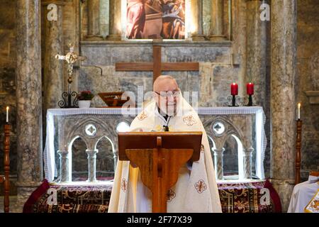 Mosul, Nineveh, Iraq. 5th Apr, 2021. Iraqi Priest preaches during the Easter mass at the Grand Immaculate Church (al-Tahira-l-Kubra) in the Qaraqosh town (Al-Hamdaniya), 30 kilometers southeast of the city of Mosul.Easter is considered the greatest and largest Christian holiday, as it commemorates the resurrection of Christ from the dead after three days of his crucifixion and death, as written in the New Testament, in which the Great Lent that usually lasts forty days ends. During the liturgy the hymns are sung, parts of the Old Testament from the Bible are recited, the hymns of the Halleluj Stock Photo