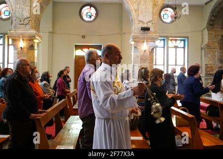 Mosul, Nineveh, Iraq. 5th Apr, 2021. Iraqi Christians attend the Easter mass at the Grand Immaculate Church (al-Tahira-l-Kubra) in the Qaraqosh town (Al-Hamdaniya), 30 kilometers southeast of the city of Mosul.Easter is considered the greatest and largest Christian holiday, as it commemorates the resurrection of Christ from the dead after three days of his crucifixion and death, as written in the New Testament, in which the Great Lent that usually lasts forty days ends. During the liturgy the hymns are sung, parts of the Old Testament from the Bible are recited, the hymns of the Hallelujah ar Stock Photo