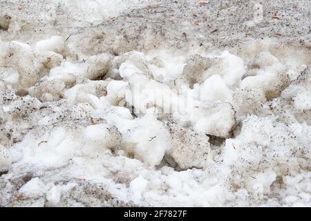 Early spring time dirty gray melted snow with sand pattern texture close-up Grunge background Stock Photo