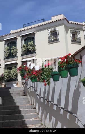 Steps half in shade with colourful flowers in pots in Estepona, Spain Stock Photo