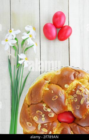 Daffodil flowers,Easter eggs and Easter bread on wooden table Stock Photo