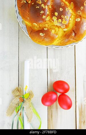 Easter candle,Easter red eggs and Easter bread on wooden table Stock Photo
