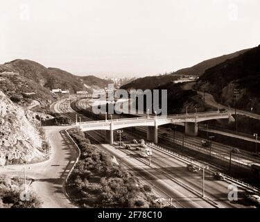 1950s CAR TRAFFIC ON HIGHWAY FREEWAY CAHUENGA BLVD HOLLYWOOD HILLS OUTSIDE LOS ANGELES CALIFORNIA USA - r4789 FST001 HARS FREEWAY AUTOMOBILES ESCAPE VEHICLES BLVD HIGH SPEED BLACK AND WHITE EXPRESSWAY LA LOS ANGELES OLD FASHIONED OVERPASS SOUTHERN CALIFORNIA Stock Photo