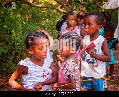 Wasini island, Kenya, AFRICA - February 26, 2020: Little local children begging for sweets from tourists on Wasini island, Kenya. This is happening in Stock Photo