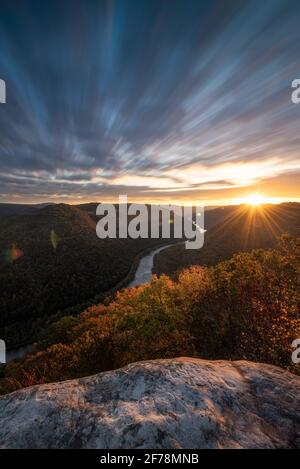 A long exposure of the morning cloud movement over the New River Gorge on a mid-October Fall morning just as the sun was cresting the mountains. Stock Photo