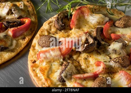 Vegetarian pita pizza. Flatbread with mushrooms, mozzarella cheese and red peppers. Stock Photo