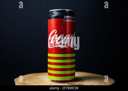 Galati, Romania, 13 April 2021 : Can of Coca Cola placed on a wooden plate in a beautiful light with a black-blueish background Stock Photo