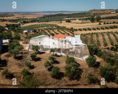 A farm built on the foundations of a former fortlet near Campo Maior overlooking the hills and lines of corktrees, a typical plant of the Alentejo region. Stock Photo