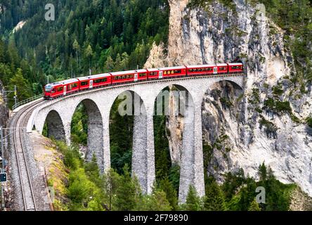 Passenger train crossing the Landwasser Viaduct in Switzerland Stock Photo