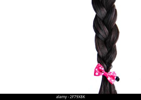 Black braided hair isolated on white background. Brunette natural braided hair extension on white background Stock Photo