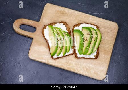 Sandwiches with soft cheese. Cereal bread toast is on the table. Stock Photo