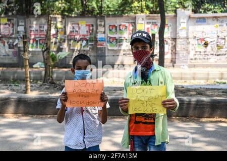 Dhaka, Bangladesh. 05th Apr, 2021. Two boys are seen standing on a street while holding placards saying 'donít accept the lockdown' at Keraniganj. (Photo by Piyas Biswas/SOPA Images/Sipa USA) Credit: Sipa USA/Alamy Live News Stock Photo