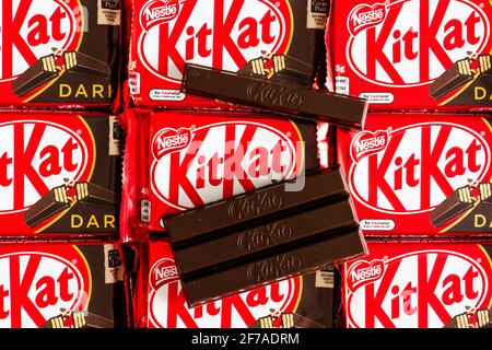 3 April 2021, Wuhan China: KitKat dark a chocolate wafer bar cut in two close-up view opened on Kit Kat background in their packaging with logo Stock Photo
